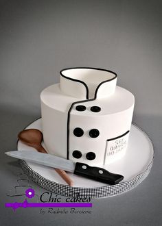 a white cake with black polka dots on it and a knife next to the cake