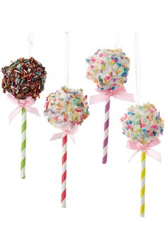 three lollipops are decorated with sprinkles and ribbons