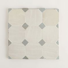 a white and grey tiled wall mounted on a wall