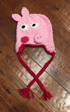 a crocheted pink pig hat with eyes and ears