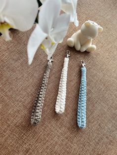 three different types of beaded earrings sitting next to each other on a table with flowers