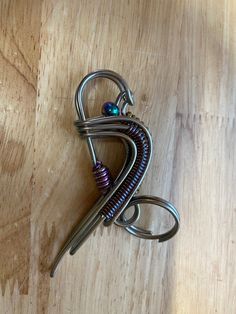 a pair of scissors sitting on top of a wooden table next to some metal wire