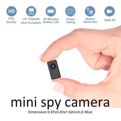 a hand holding a small black object in it's left hand with the words mini camera below