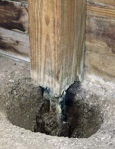 a hole in the ground that has been dug into by a wooden post and cement