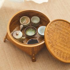 a wooden table topped with lots of bowls and saucers on top of a rug