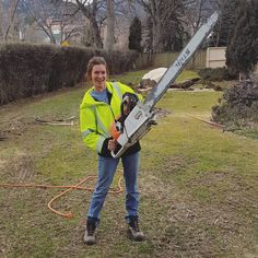 a woman holding a chainsaw in her hands