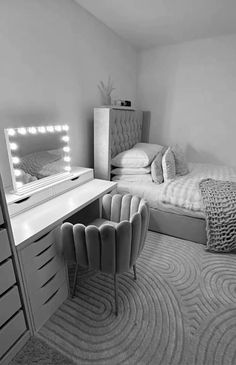 black and white photograph of a bedroom with a bed, dresser, mirror and chair