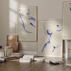 three framed art work on the wall in an empty room with hard wood flooring