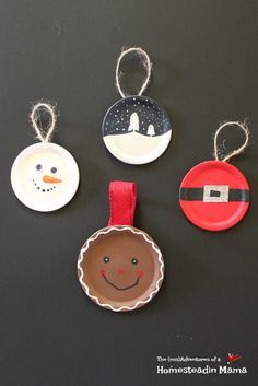 three paper plates with christmas ornaments hanging from them on a black surface, one has a snowman and the other is a santa clause