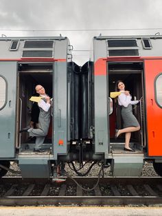 two people standing in the open doors of a train