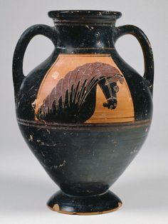 an old black and orange vase with a horse on it's side, sitting on a white surface