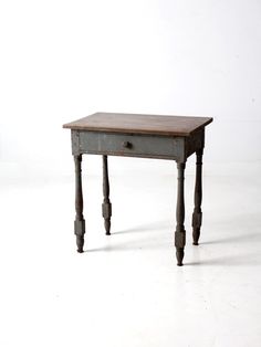 an old wooden table sitting on top of a white floor