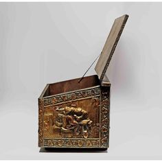 an ornate wooden box with carvings on the lid and sides, holding a string in its mouth