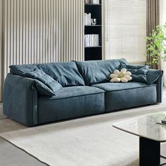 a living room filled with furniture and a large window covered in shades of blue curtains