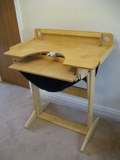 a wooden desk with a laptop on it and a mouse in the bottom half of the desk