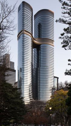 two very tall buildings in the middle of a park