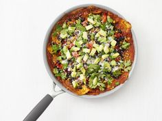 a pizza with avocado and other toppings in a pan