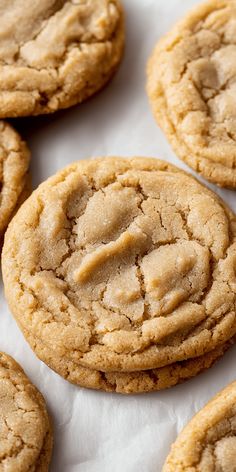 a close up of several cookies on a white tablecloth with one cookie in the middle