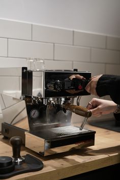 a person is using a coffee machine on a counter