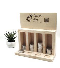 a wooden box with stacks of coins in it and a potted plant next to it