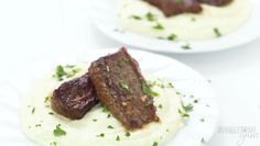 two white plates topped with meat and mashed potatoes