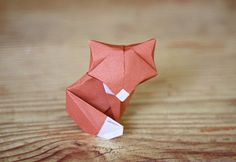 an origami fox sitting on top of a wooden table