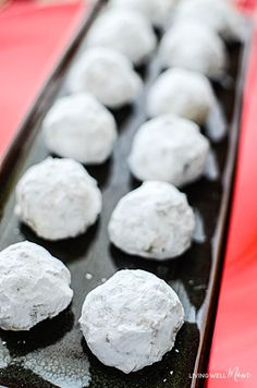 there are many snowball cookies on the tray