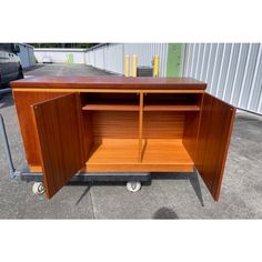 a wooden cabinet sitting on top of a metal cart