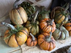 several pumpkins and gourds sitting on a table