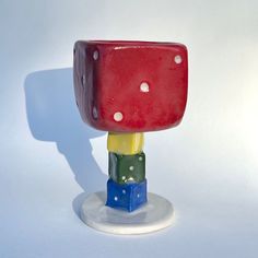 a red, yellow and green toy sitting on top of a white table