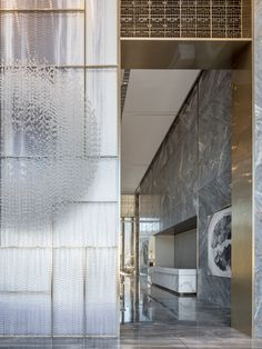 the entrance to an office building is covered in metallic foil and features intricately designed glass panels