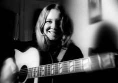 a black and white photo of a woman playing an acoustic guitar