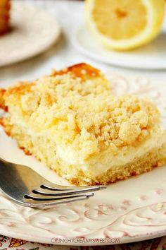 a piece of cake on a plate with a fork next to it and lemons in the background