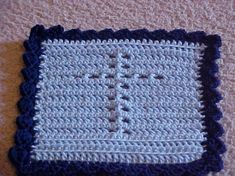 a crocheted blue and white dishcloth on a beige surface with black edges