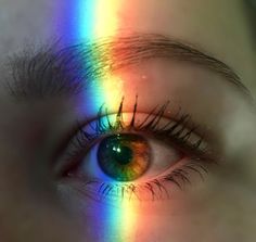 a person's eye is shown with the rainbow in it