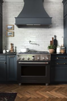 a stove top oven sitting inside of a kitchen next to a wooden floored floor