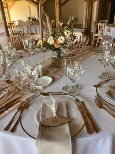 the table is set with silverware and place settings