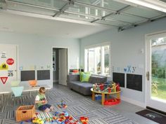 a child playing in a playroom with toys on the floor and large sliding glass doors