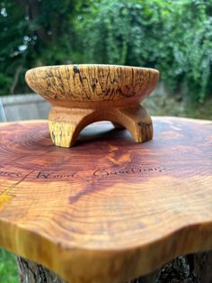 a wooden bowl sitting on top of a tree stump