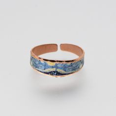 an image of a ring with blue and yellow paint on the inside, it is made out of copper