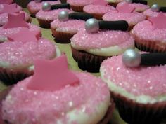 cupcakes with pink frosting and stars on them are arranged in a row