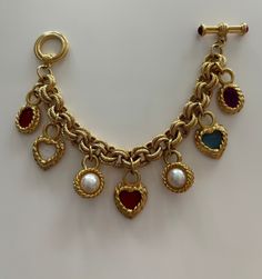 This stunning Givenchy vintage charm bracelet is sure to add a splash of whimsical elegance to any outfit. It is in excellent condition. Missing Givenchy logo hang tag. Please see photos to truly appreciate the beauty of this rare treasure. This item is vintage - no returns/refunds. Vintage Yellow Gold Jewelry With Logo Charm, Vintage Gold-tone Jewelry With Logo Charm, Elegant Vintage Charm Dangle Bracelets, Vintage Gold Bracelet With Logo Charm, Elegant Dangle Bracelets With Vintage Charm, Vintage Formal Charm Bracelet, Vintage Gold-tone Jewelry With Toggle Clasp, Elegant Metal Charm Bracelet Collectible, Elegant Metal Charm Bracelet For Collectors