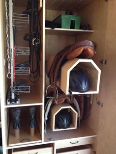 the inside of a wooden cabinet with many different items in it, including boots and hats