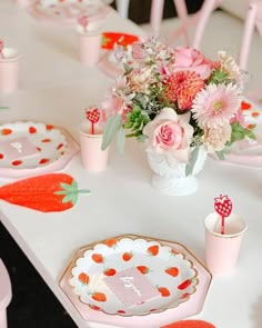 the table is set with pink and white plates