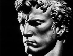 a black and white photo of a statue of a man's head with curly hair