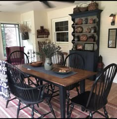 the dining room table is set with black chairs and an old china cabinet in the background