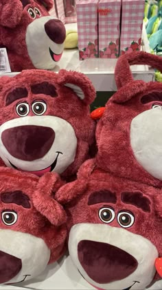 several red teddy bears are on display in a store