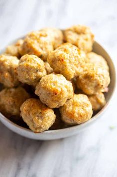 a white bowl filled with meatballs on top of a table