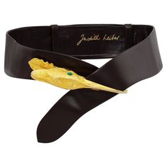 Very interesting and unique Judith Leiber statement belt from the early 1990s. Chocolate brown supple leather with a very large gold tone metal bird head buckle. The bird features an engraved head to give the illusion of feathers and faux emerald cabochon eyes. The long beak opens when the back of the head is pressed down and has a small bar that goes through the belt hole. The belt only has one hole, as the back is adjustable, with 34.5" being the largest it goes. Interior gold brand markings. Belt Hole, Judith Leiber Bags, Bird Head, Emerald Cabochon, Chanel Runway, Statement Belt, Small Bar, Back Of The Head, Gold Belts