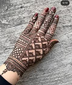 a woman's hand with henna tattoos on it